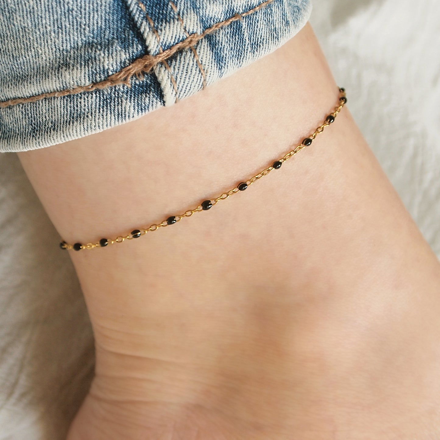 dainty woman ankle bracelet with small black beads