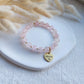 beaded stretch bracelet made with natural rose quartz beads, bracelet has detachable heart charm with custom engraving, charm can be engraved from both sides