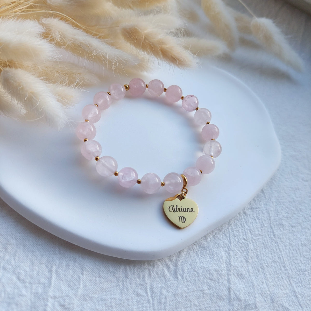 beaded stretch bracelet made with natural rose quartz beads, bracelet has detachable heart charm with custom engraving, charm can be engraved from both sides